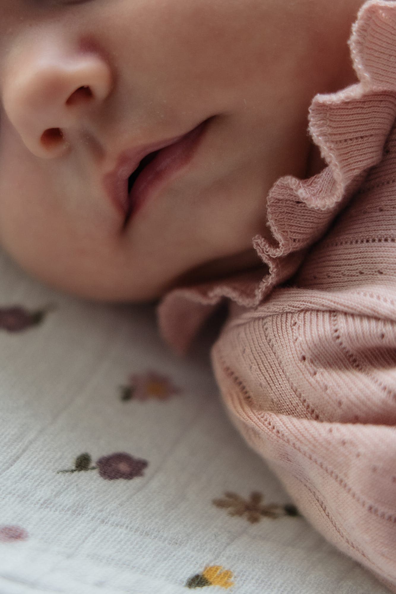 Close-up van het mondje en een roze ruche van een slapende newborn